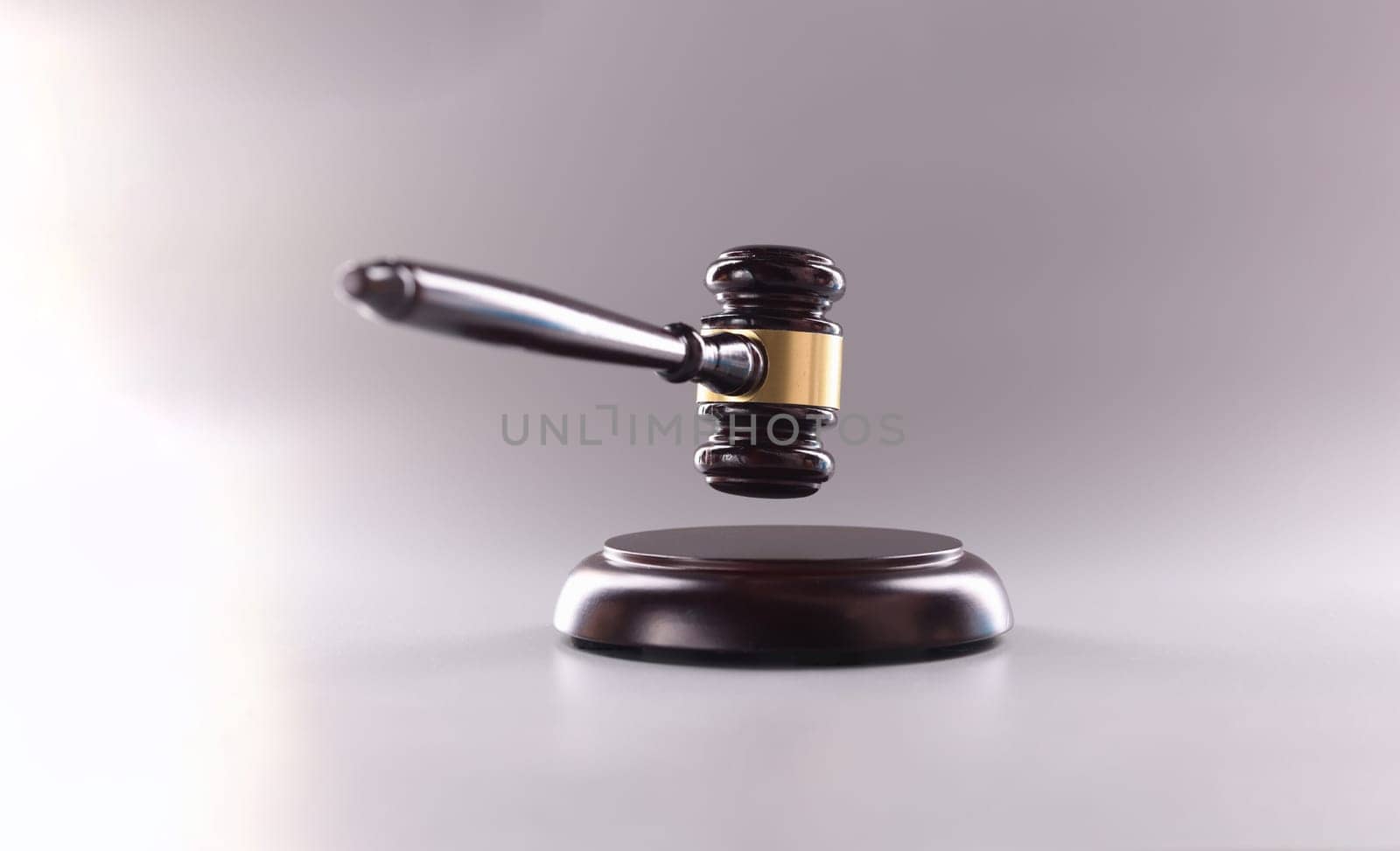 Wooden judge gavel in air on gray background. Judgment verdict or auction concept