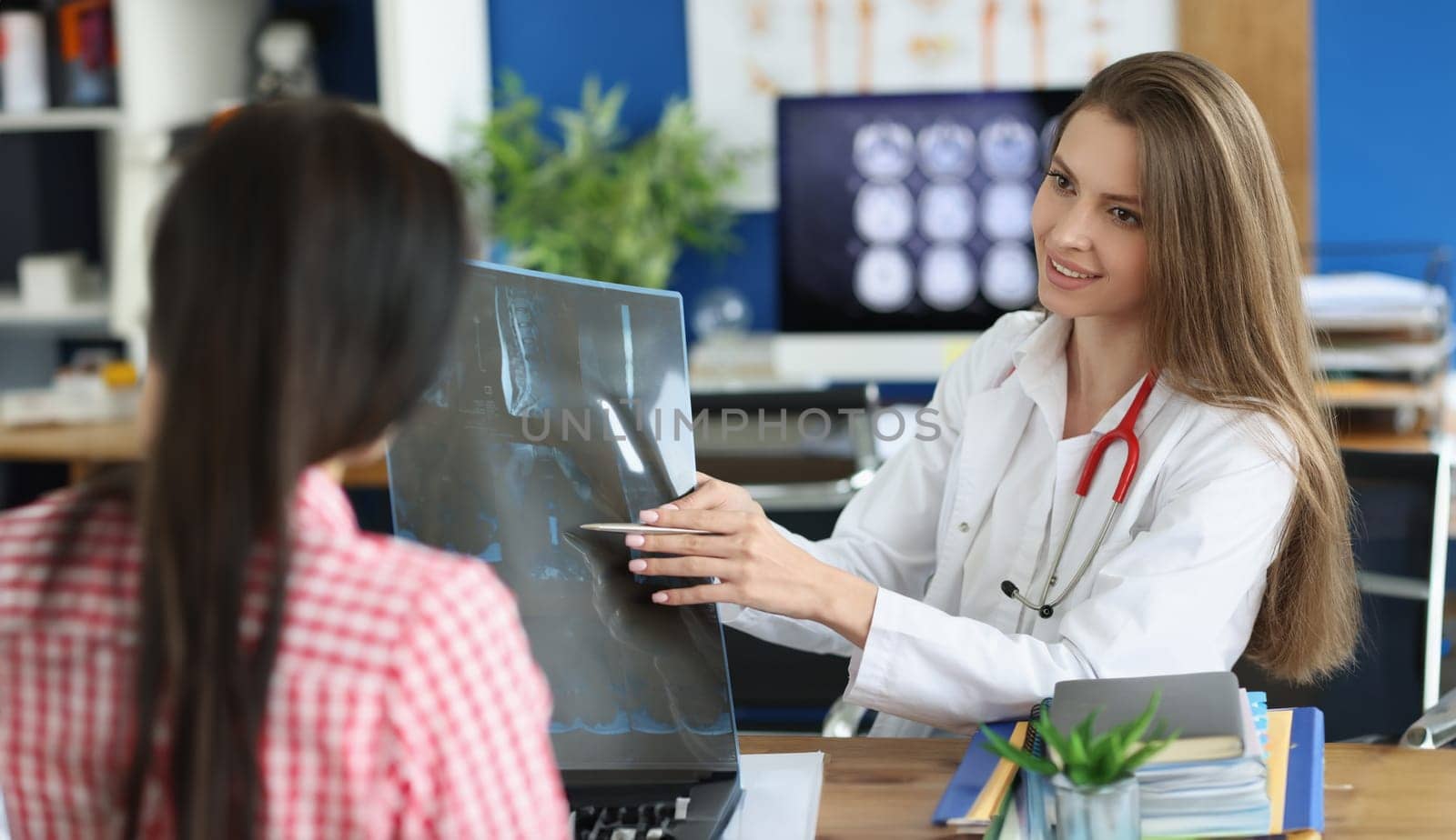 Female patient and doctor with spine x-ray scan meet in hospital. Injury and pain in spines diagnosis and treatment concept