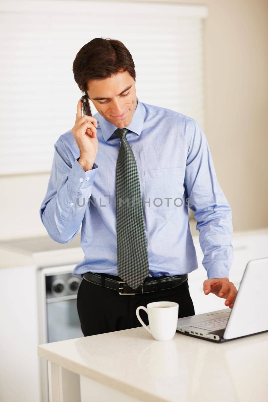 Businessman, phone call and laptop with coffee for discussion or communication in kitchen at home. Man or employee talking on mobile smartphone for morning conversation, computer and tea at house by YuriArcurs