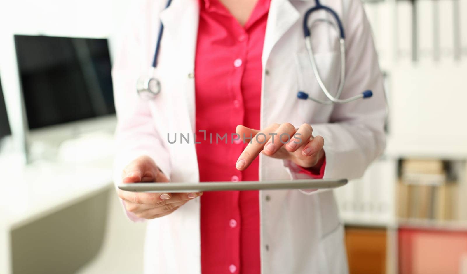 Female doctor is holding modern tablet and using remote telemedicine application. Telehealth concept and remote medical care