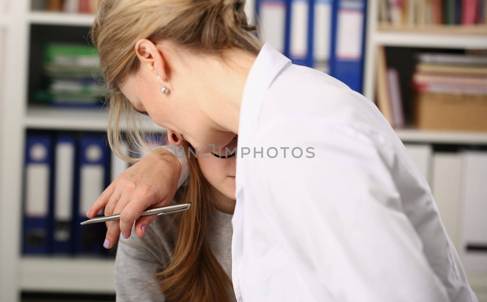 Doctor woman tightly hugs girl in clinic by kuprevich