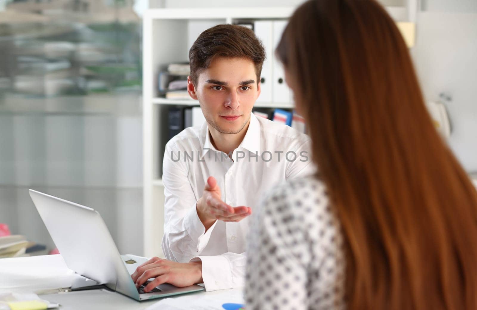 Young manager consultant explains business project to female colleague. Communication business people workplace concept