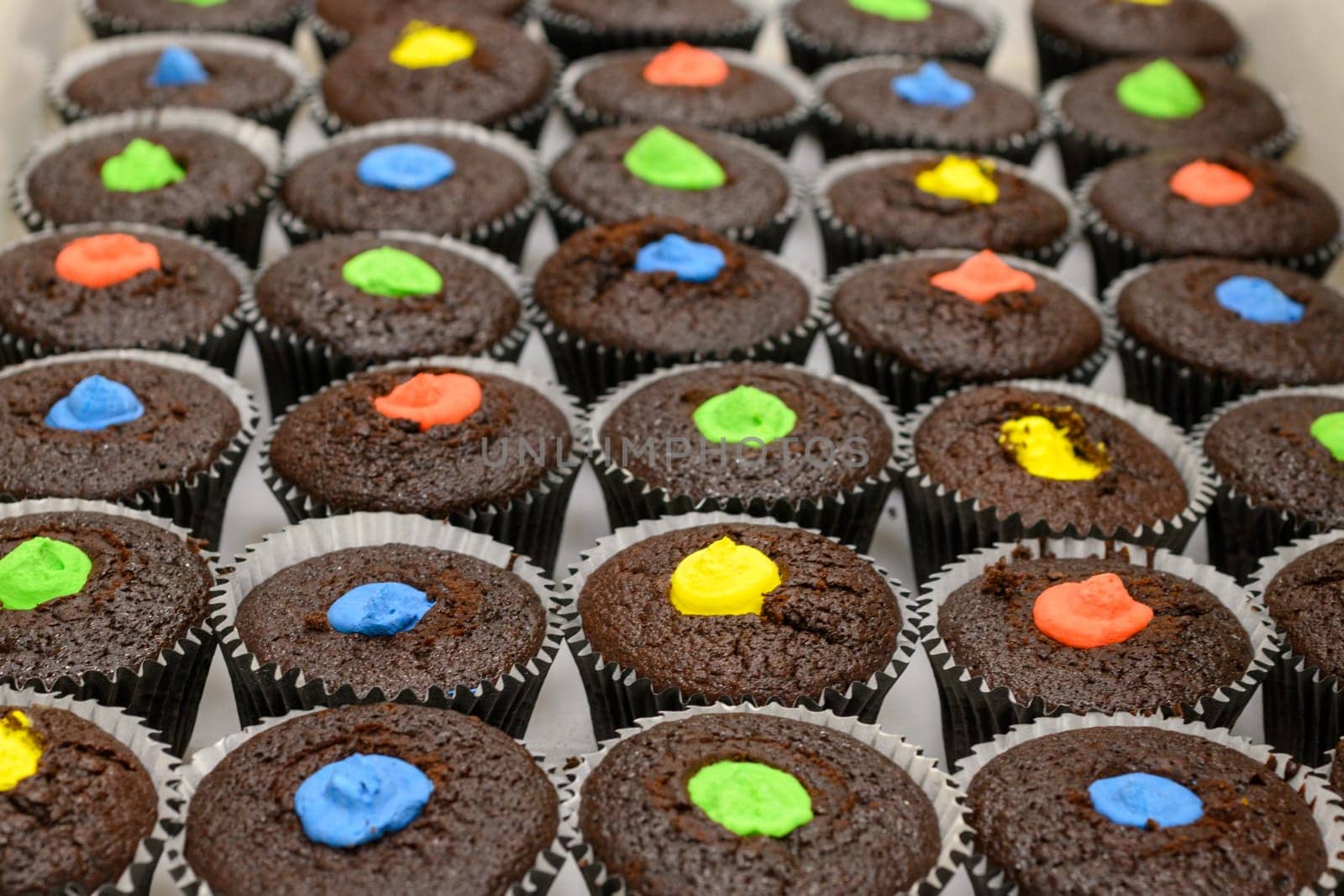 multi color muffins produce at professional catering baker in professional kitchen