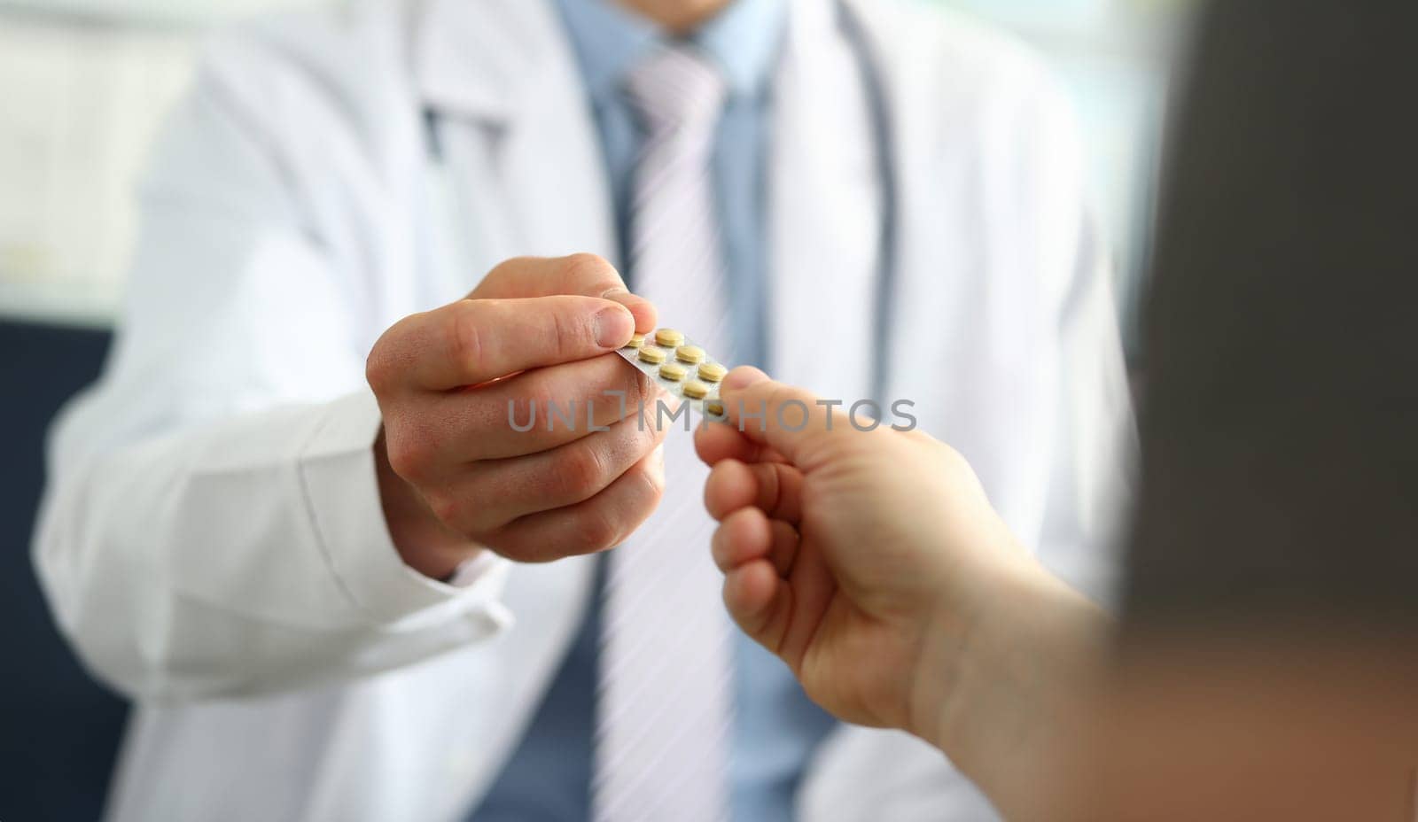 Closeup of doctor hand giving medical pills to patient. Prescribing medications to patient in illness concept