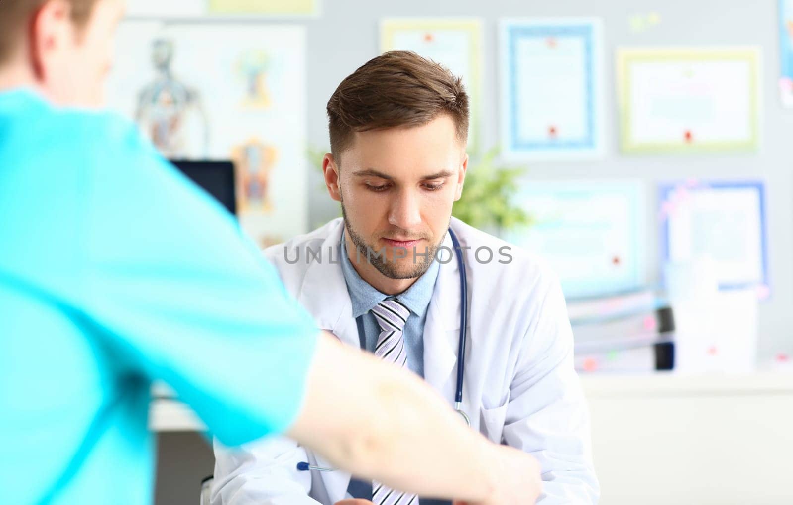Doctor talks and listens to patient in clinic by kuprevich