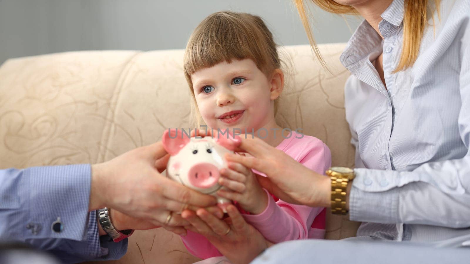 Young parents and little child girl are holding piggy bank. Family budget savings and saving money concept