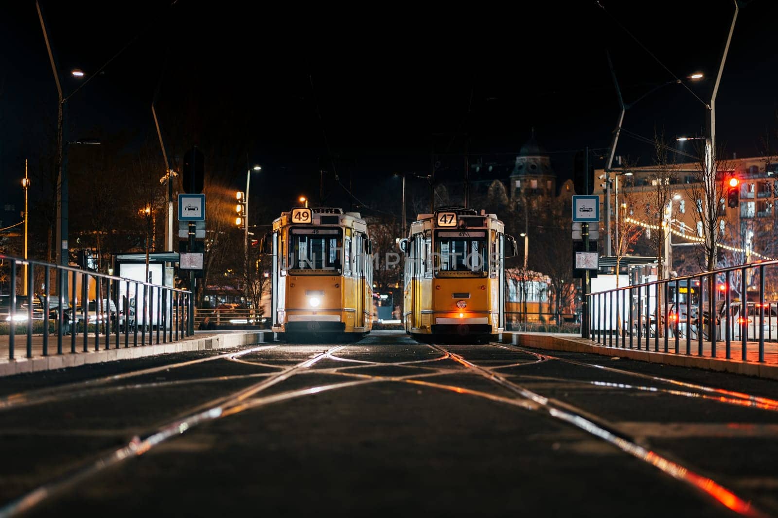 Resting trams locate on rails in city street at night time by apavlin