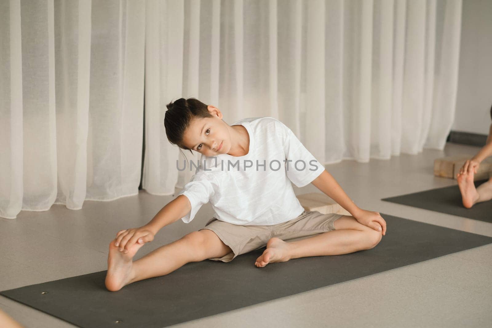 A child does yoga in the gym. Children's gymnastics by Lobachad