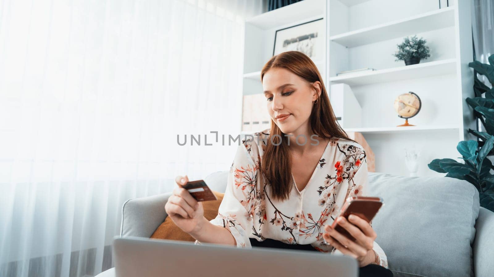 Young happy woman buy product by online shopping at home while ordering items from the internet with credit card online payment system protected by utmost cyber security from online store platform