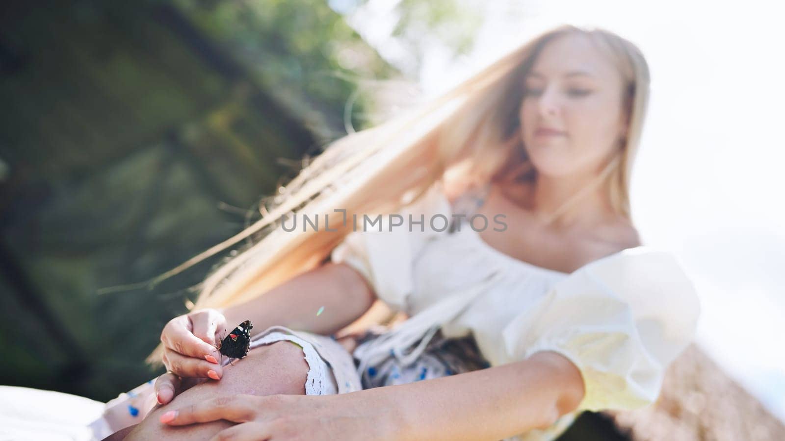 Young blonde girl with a butterfly on a summer afternoon. by DovidPro