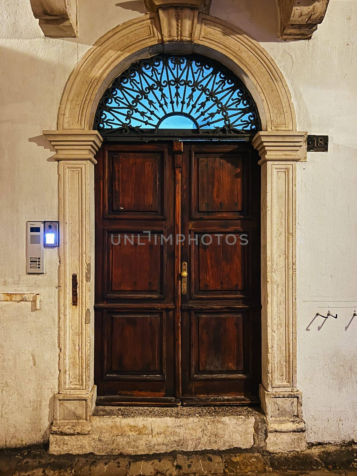 Budva, Montenegro - 25 december 2022: Arched wooden door in an old mansion by Nadtochiy