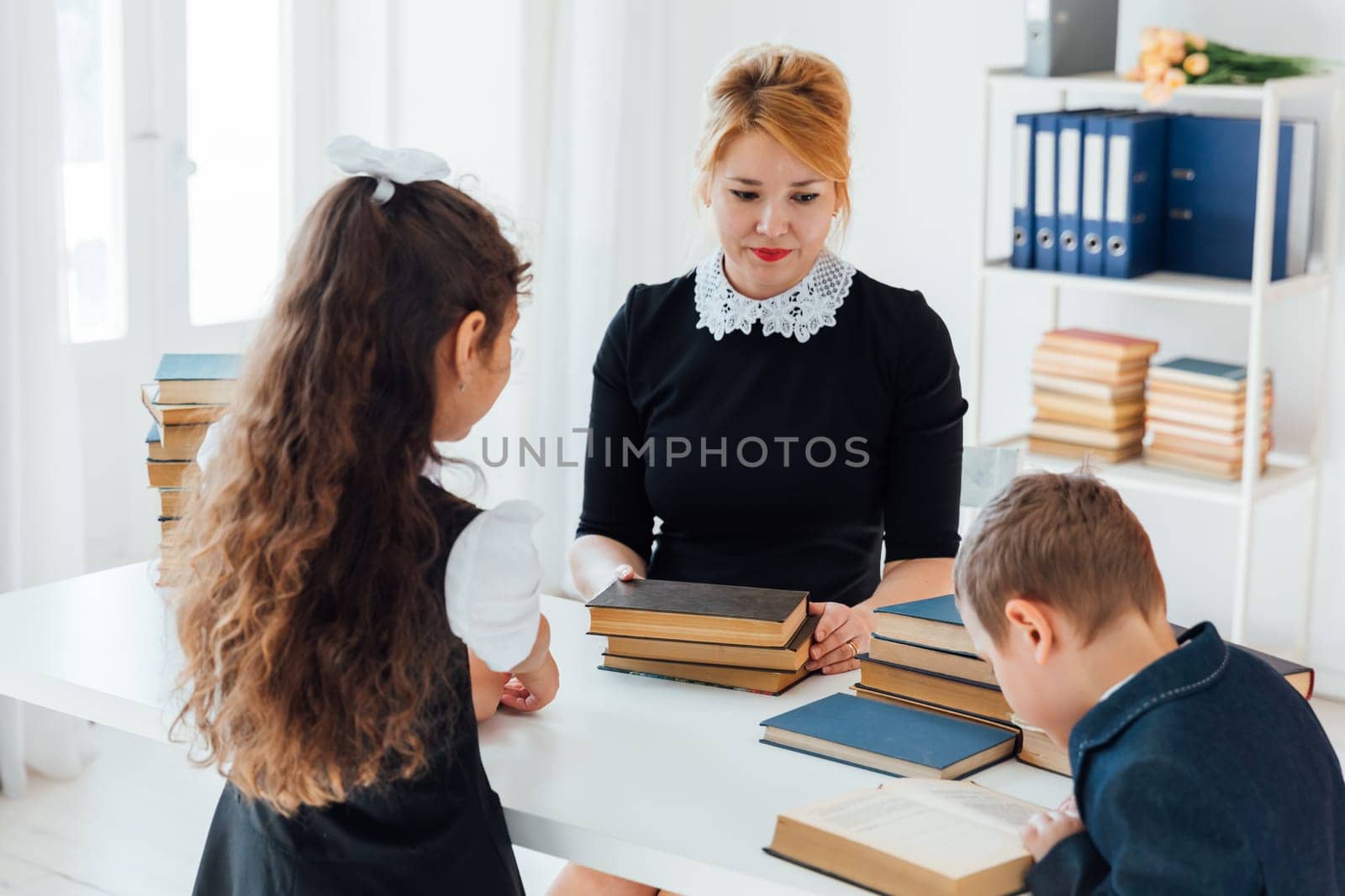 teacher at lesson at school with children and books