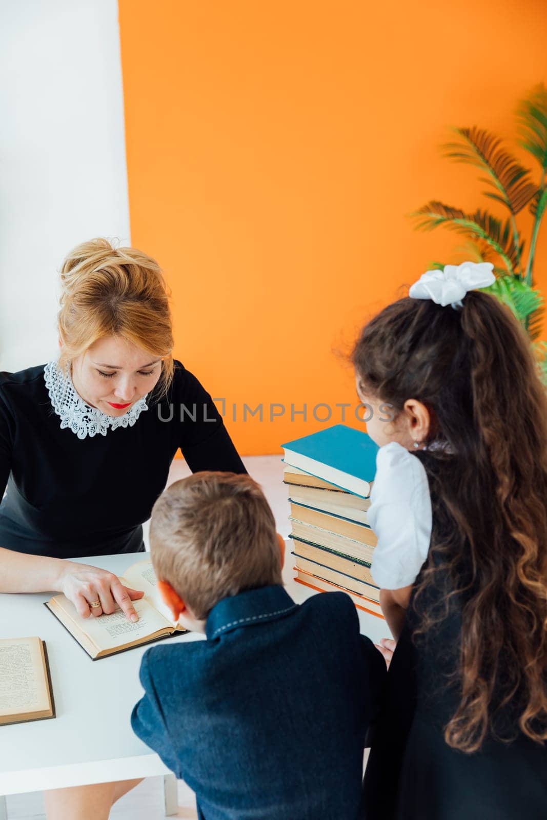 Teacher at literature lesson at school with children and books by Simakov