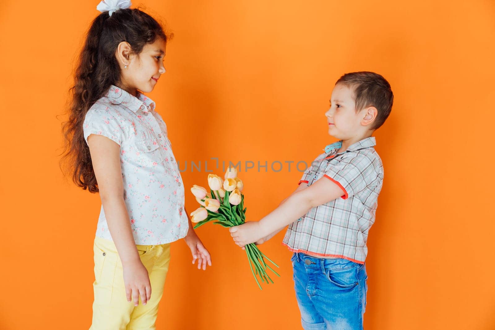 Little boy giving flowers to a girl by Simakov