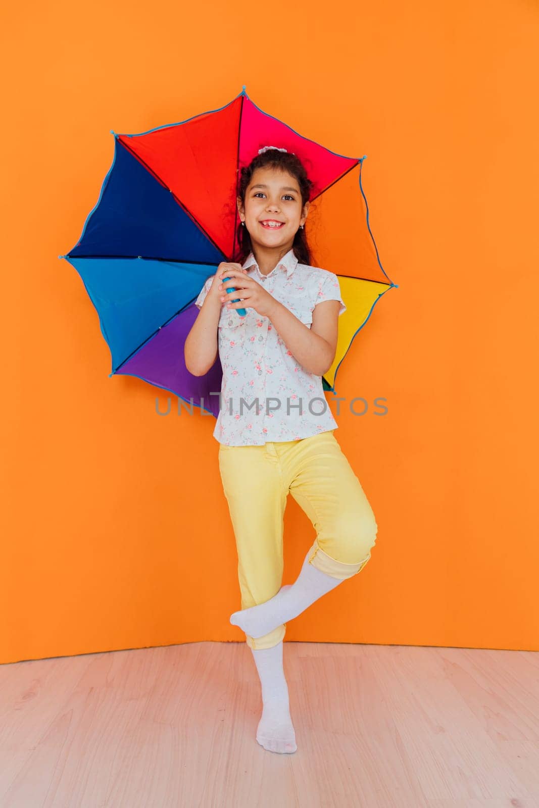 girl under colorful umbrella from the rain