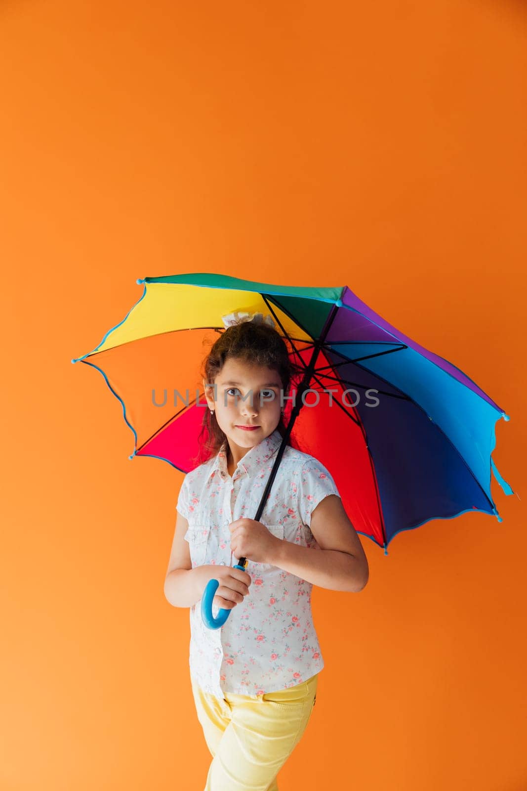 Beautiful girl under colorful umbrella from the rain by Simakov