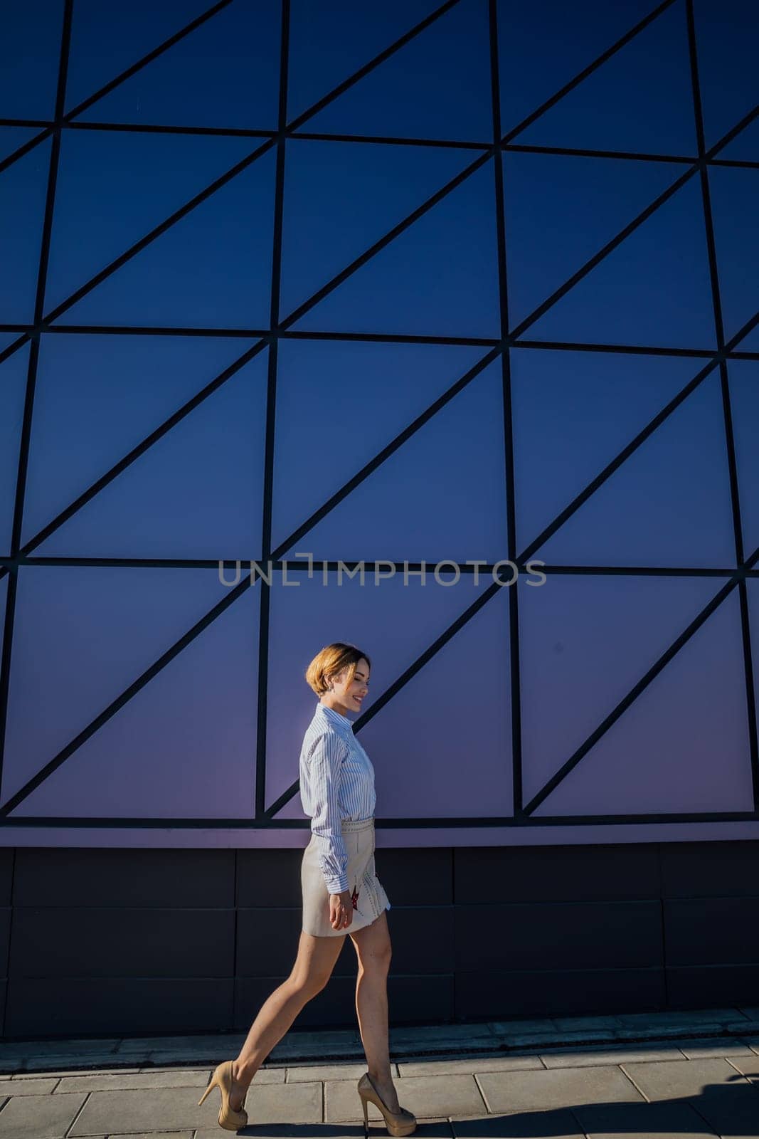 Beautiful fashionable woman near glass wall showcase by Simakov