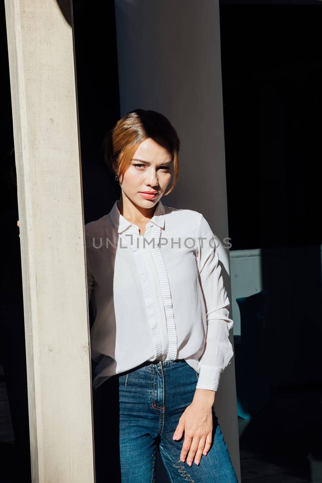 Fashionable woman standing at a wooden doorway by Simakov