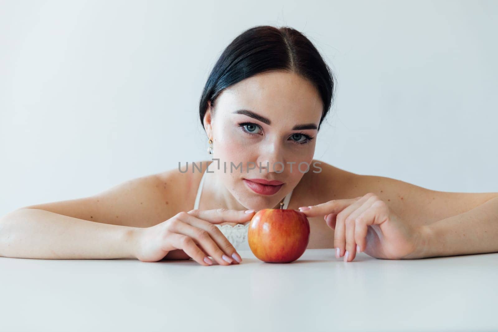 brunette woman with apple in bright room