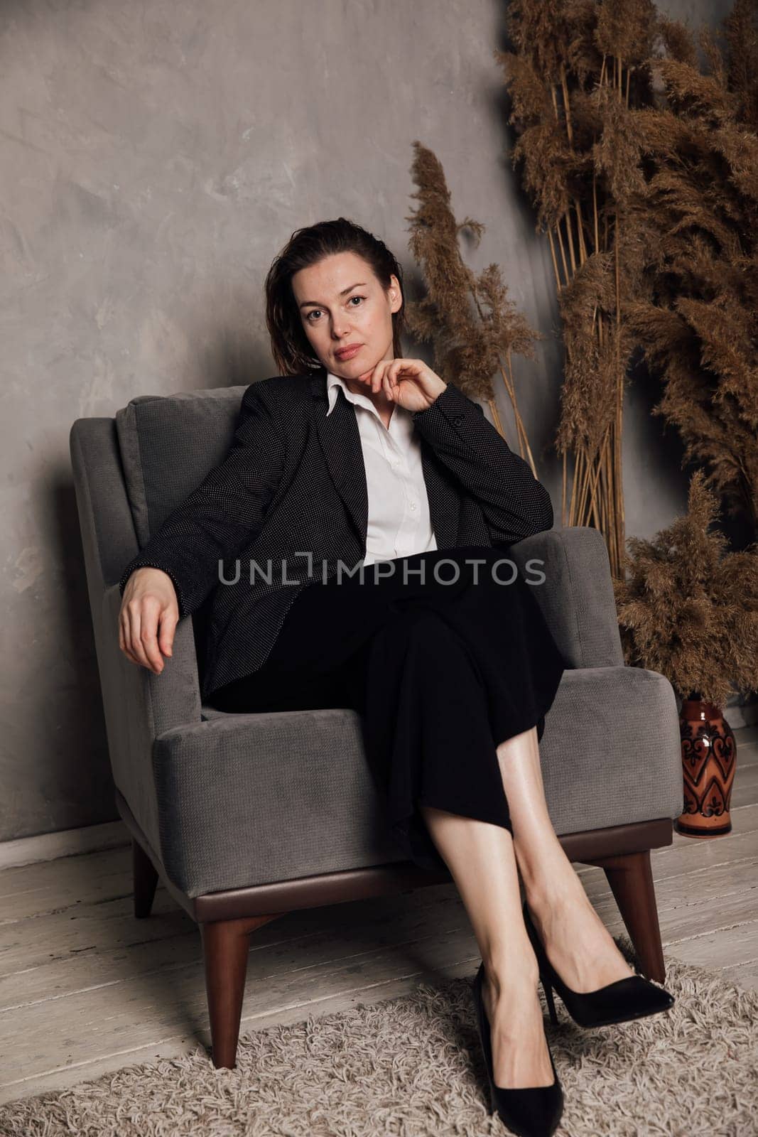 A woman sits in an armchair in an office