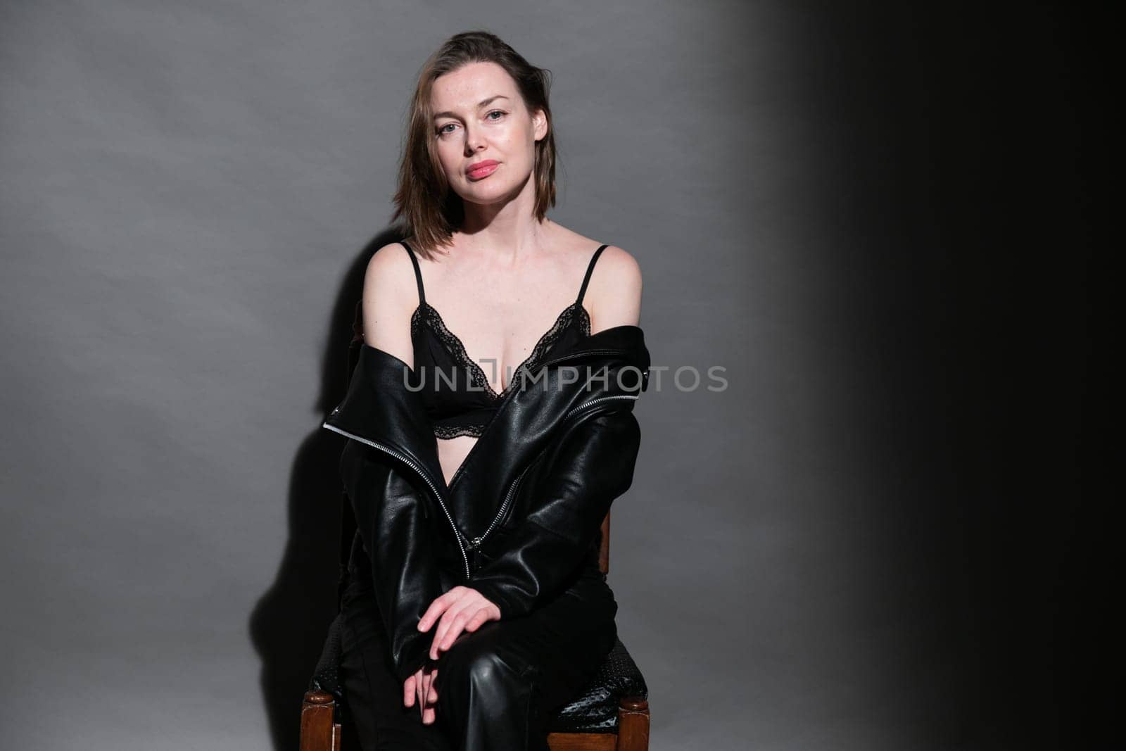 Woman in black clothes sitting on a chair in a dark