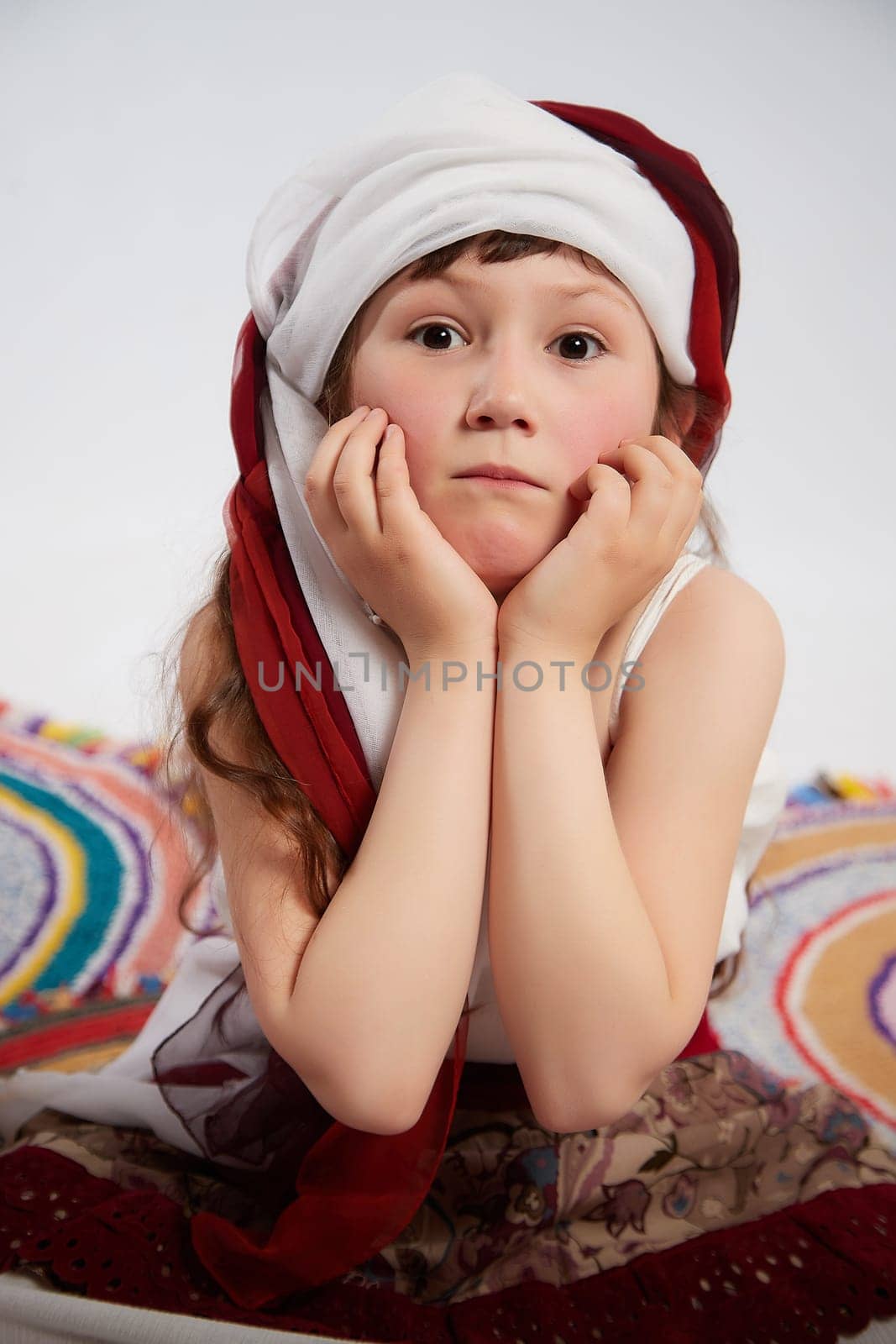 Portrait of Little girl in a stylized Tatar national costume on a white background in the studio. Photo shoot of funny young teenager who is not professional model by keleny