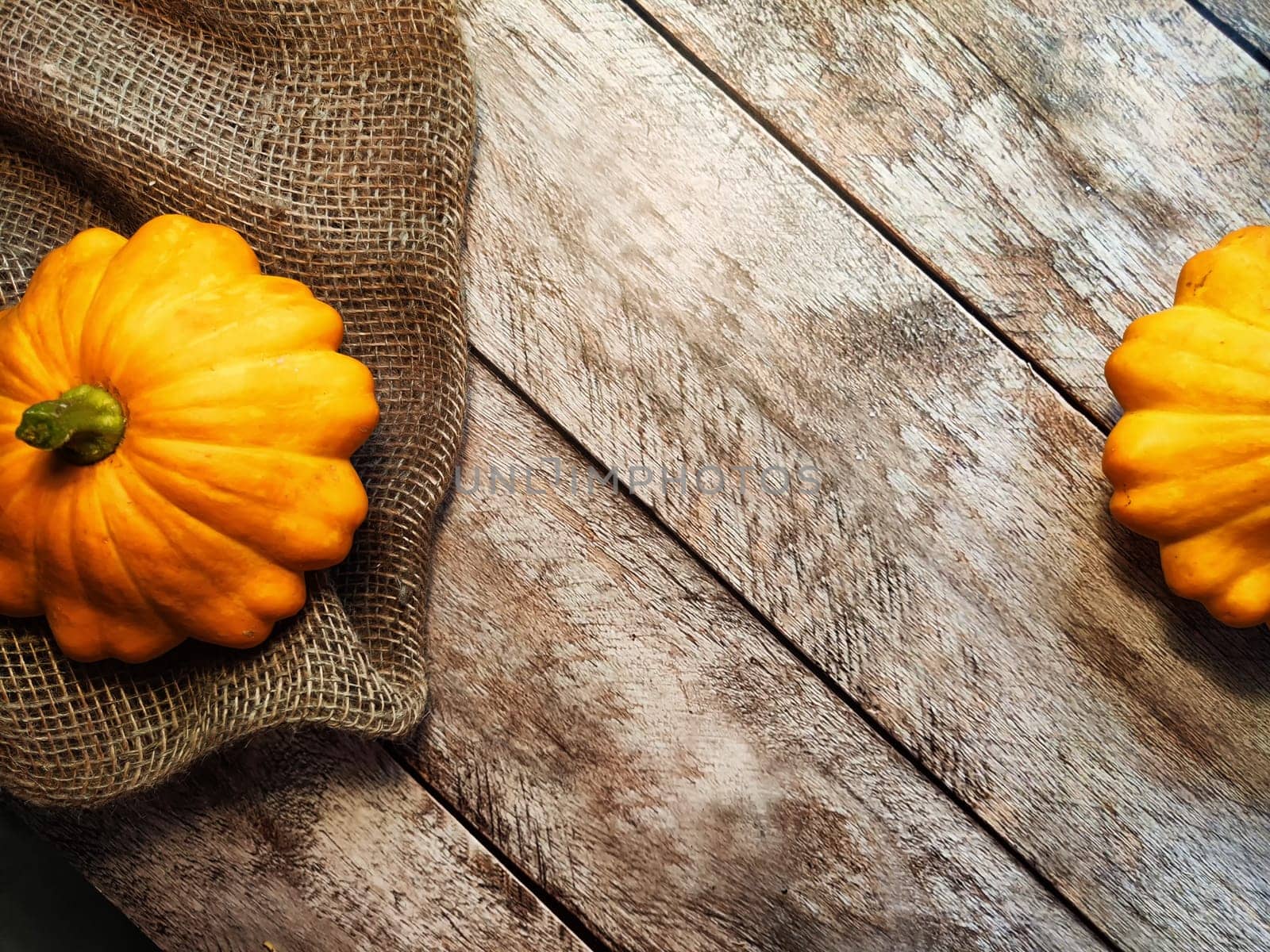 Yellow pattison on wooden boards of table and on the fabric is sackcloth or burlap. Healthy Delicious Beautiful Vegetable in autumn. Abstract Background, texture, frame, place for text and copy space by keleny