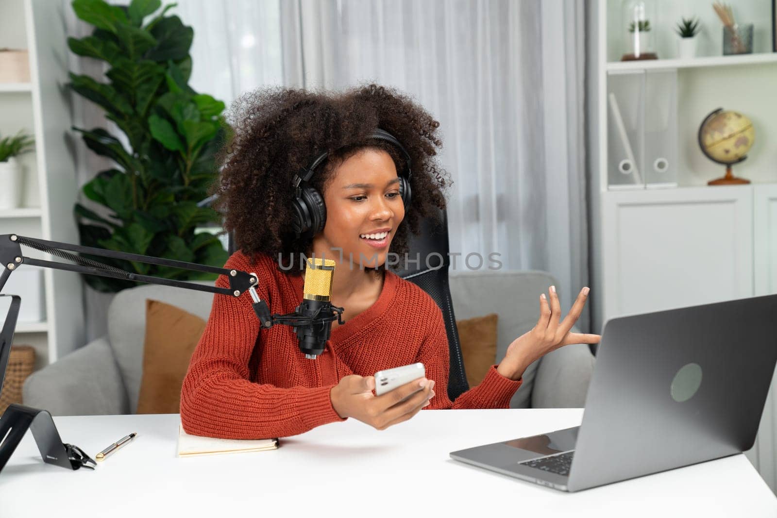 Host channel of beautiful African woman talking in online broadcast teaching marketing influencer, with listeners in broadcast or online. Concept of anywhere at work place. Tastemaker.