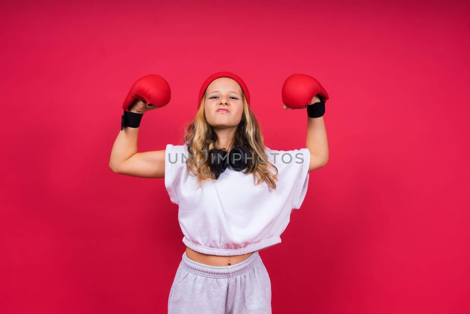 Little girl wearing red boxing gloves, studio shot, sport conception