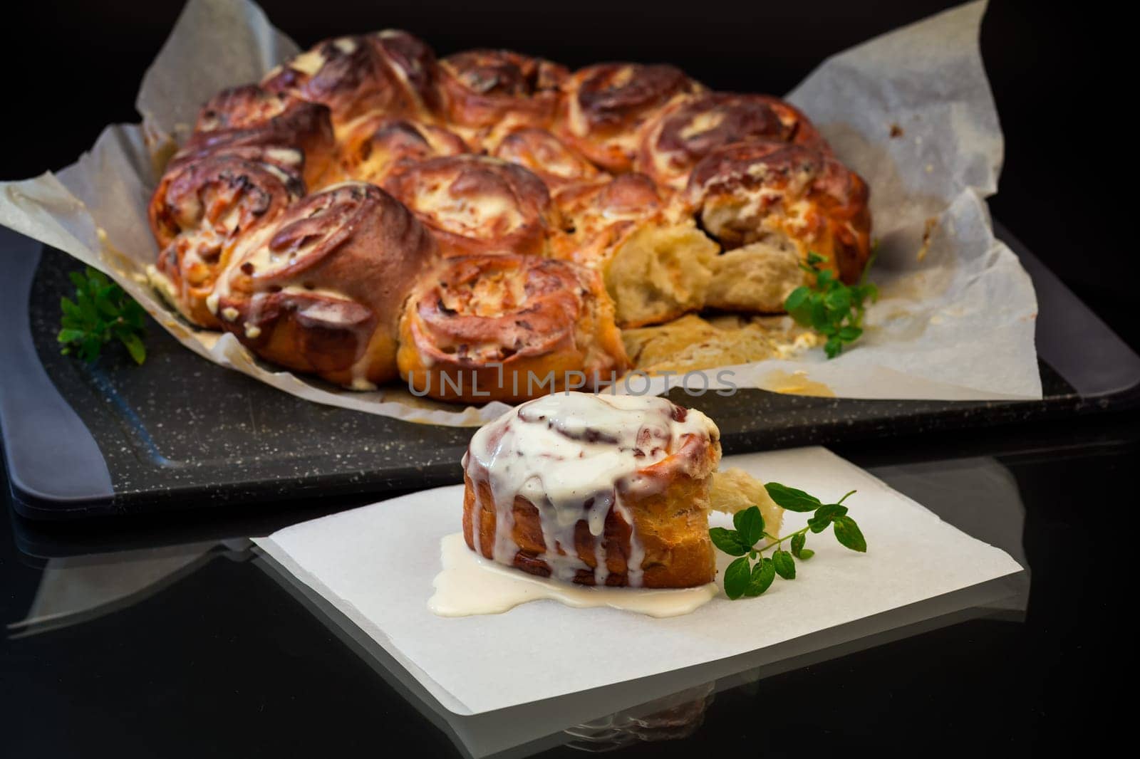 cooked baked sweet Cinnabon with cream isolated on black background