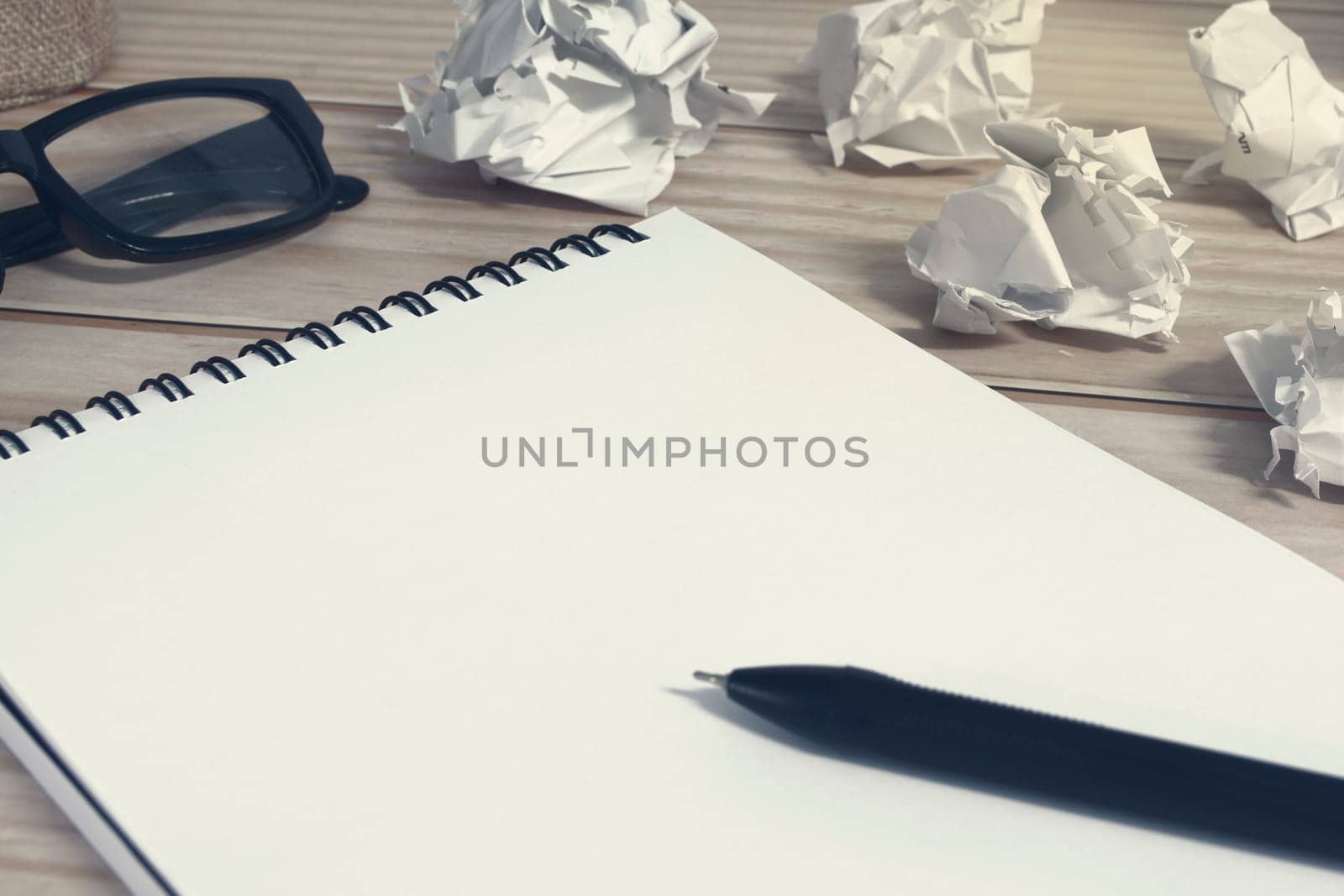 Notepad with trash paper background on wooden desk. Copy space.