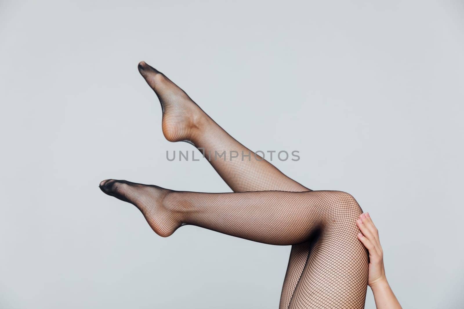 Beautiful slender female legs in black pantyhose stockings as background by Simakov