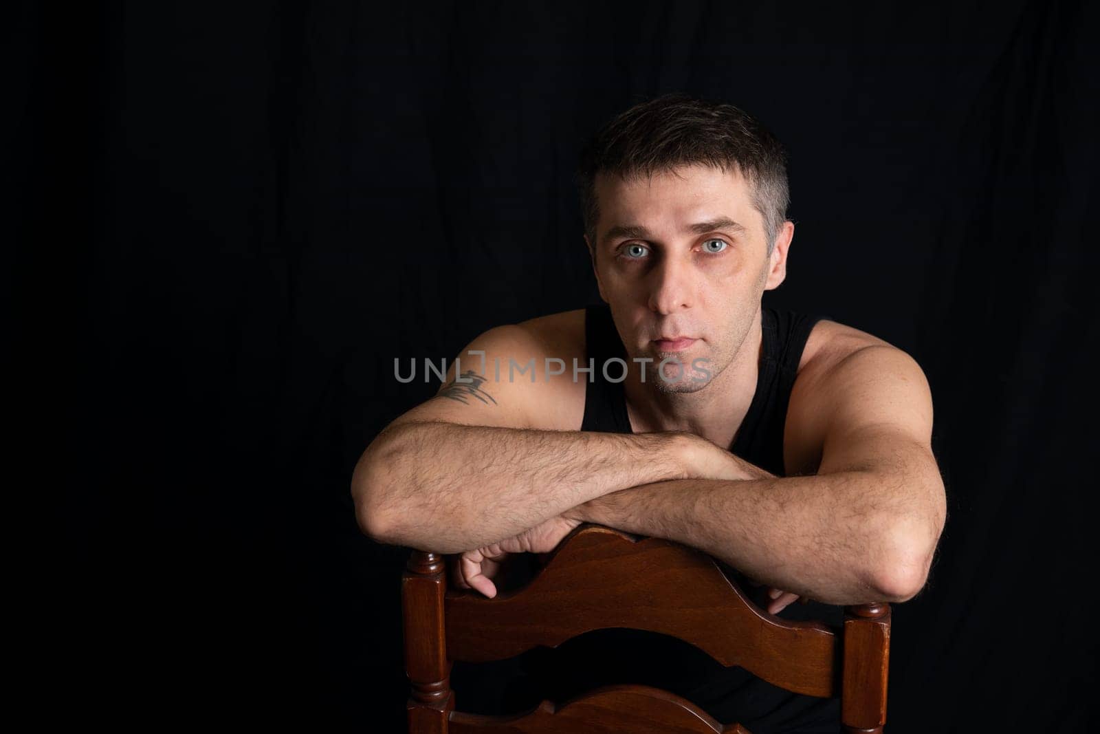 Portrait of a 40-year-old man in black clothes on a dark background by Simakov