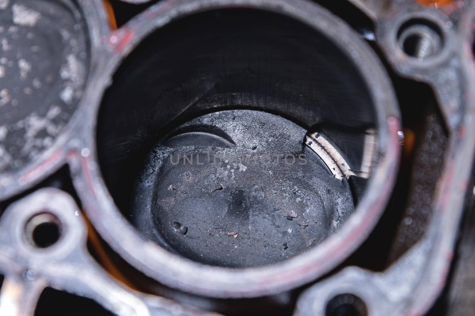 Close-up of a damaged piston of an internal combustion engine with carbon deposits in the cylinder block of a faulty engine by yanik88
