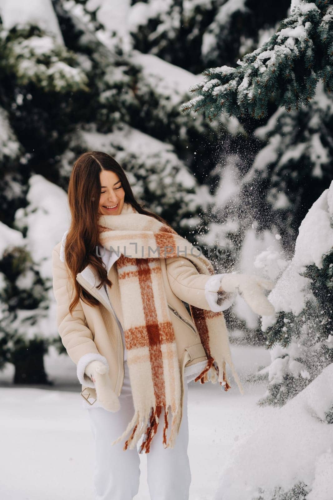 Portrait of a girl with long hair in mittens in a winter forest . Snowy winter by Lobachad