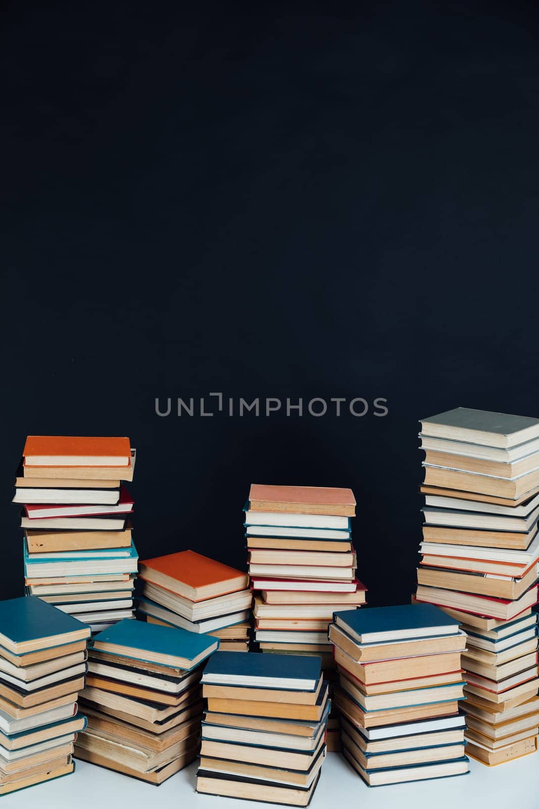 Lots of stacks of educational books on black background library