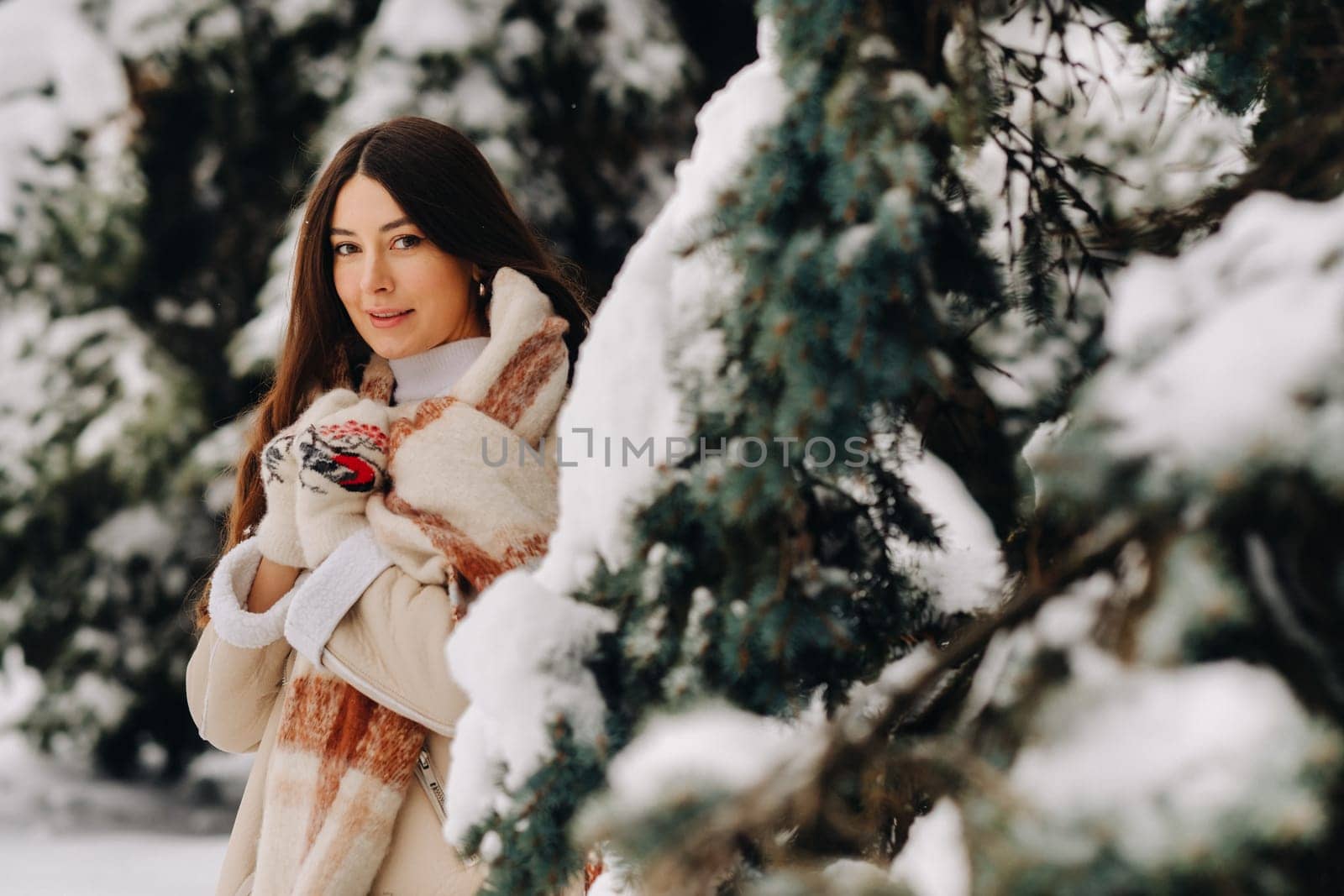 Portrait of a girl with long hair in mittens in a winter forest . Snowy winter by Lobachad