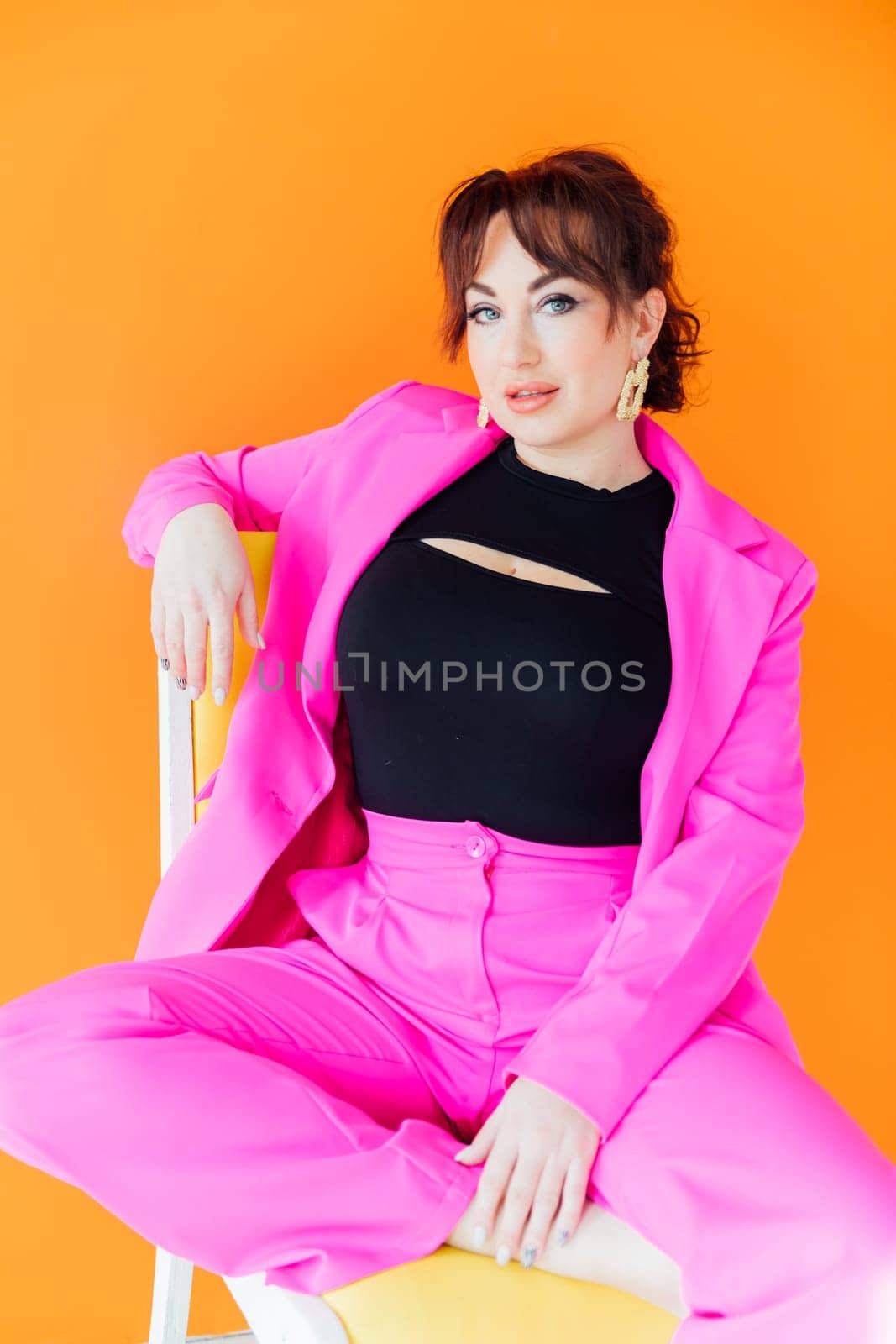 Portrait of a beautiful woman in a purple business suit on a chair