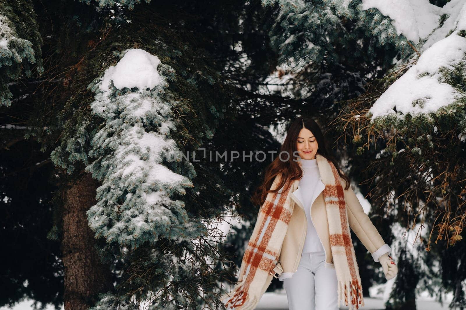 Portrait of a girl with long hair in mittens in a winter forest . Snowy winter.