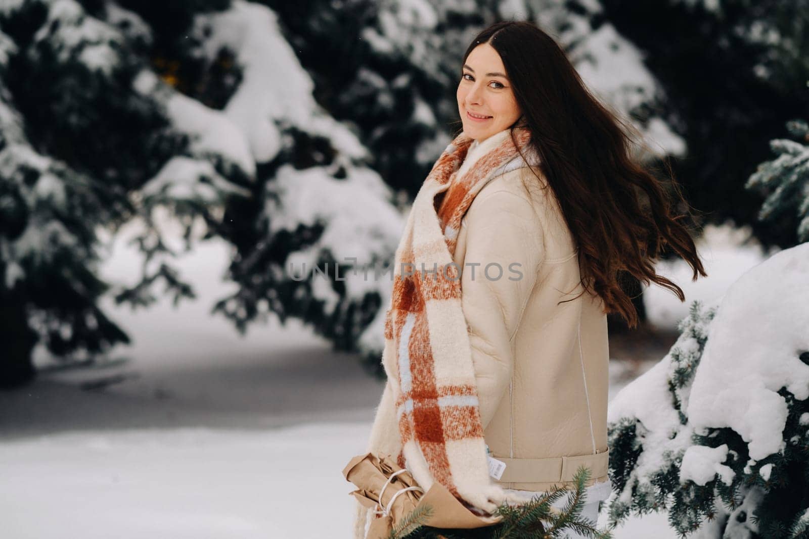 A girl in a winter forest with a bouquet of fir branches. Snowy winter by Lobachad