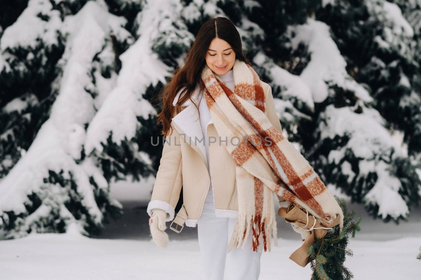 A girl in a winter forest with a bouquet of fir branches. Snowy winter by Lobachad