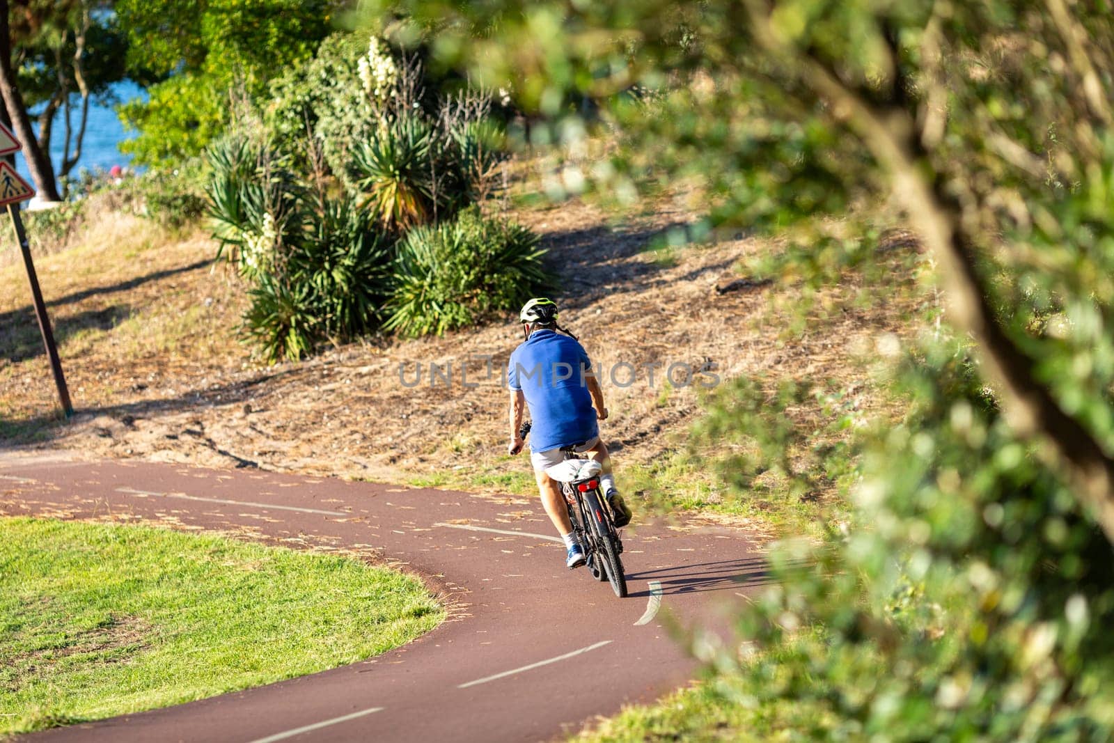 Person riding a bicycle on a cycle path a sunny day