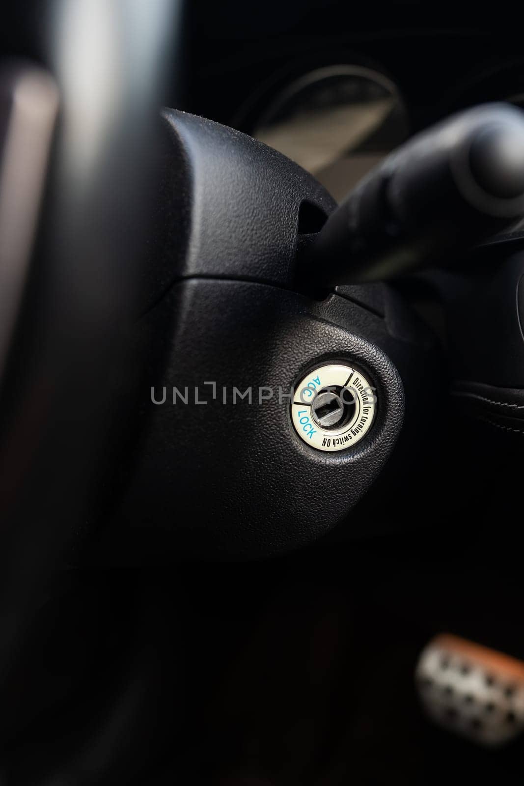 Close-up of a car ignition keyhole with a blurred dashboard background. by sfinks
