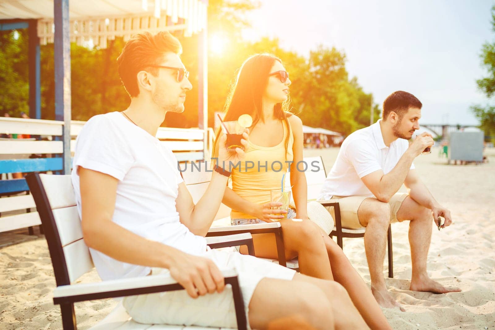 Young people enjoying summer vacation sunbathing drinking at beach bar by nazarovsergey