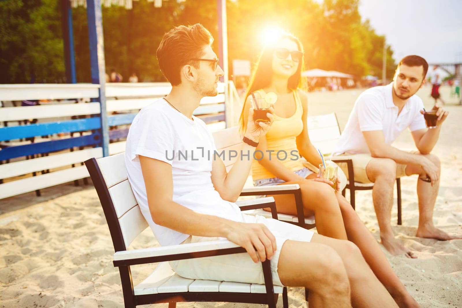 Young people enjoying summer vacation sunbathing drinking at beach bar by nazarovsergey