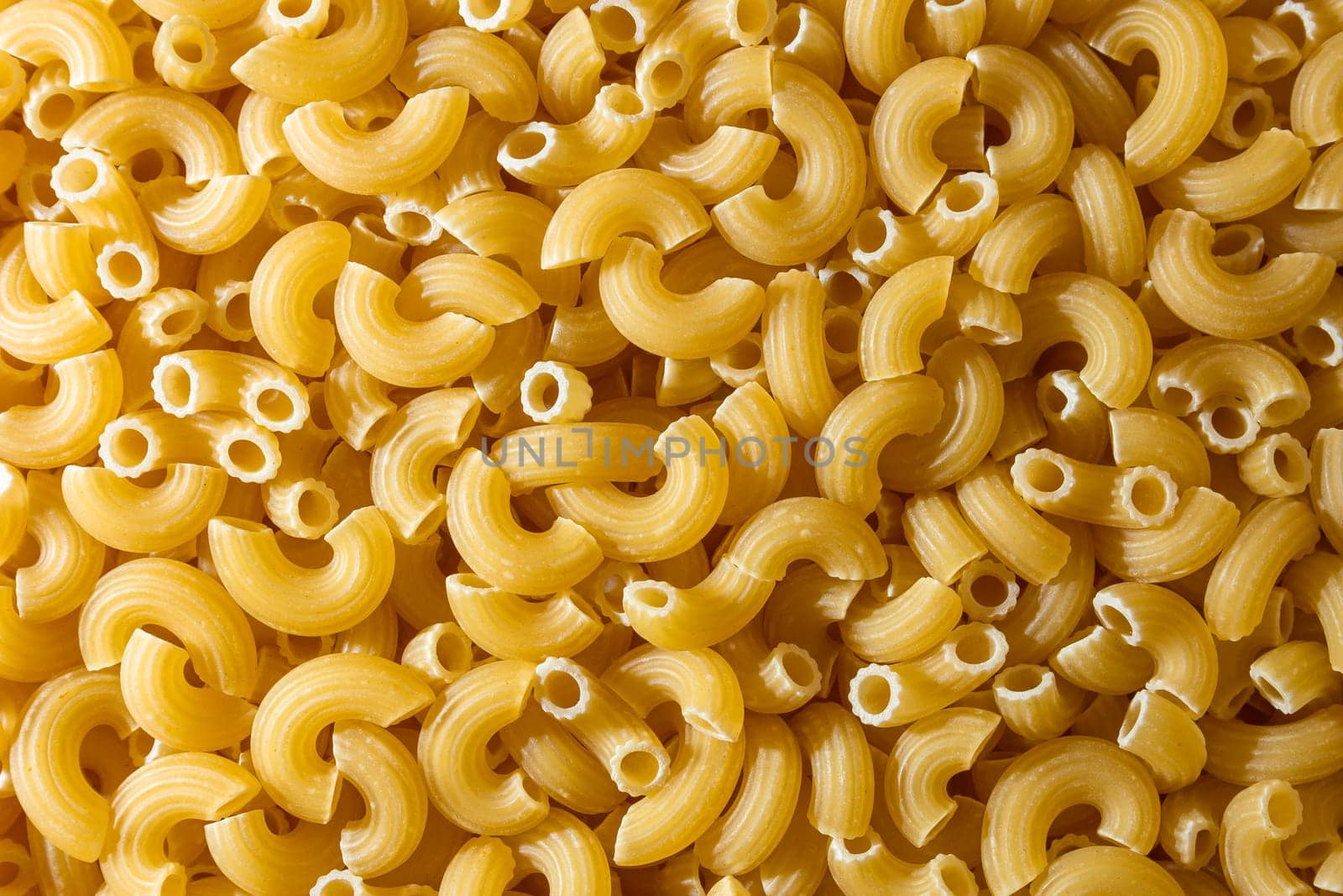 Uncooked Chifferi Rigati Pasta: A Culinary Canvas of Chifferi Rigati, Creating a Lively and Textured Background for Gourmet Cooking. Dry Pasta. Raw Macaroni - Top View, Flat Lay