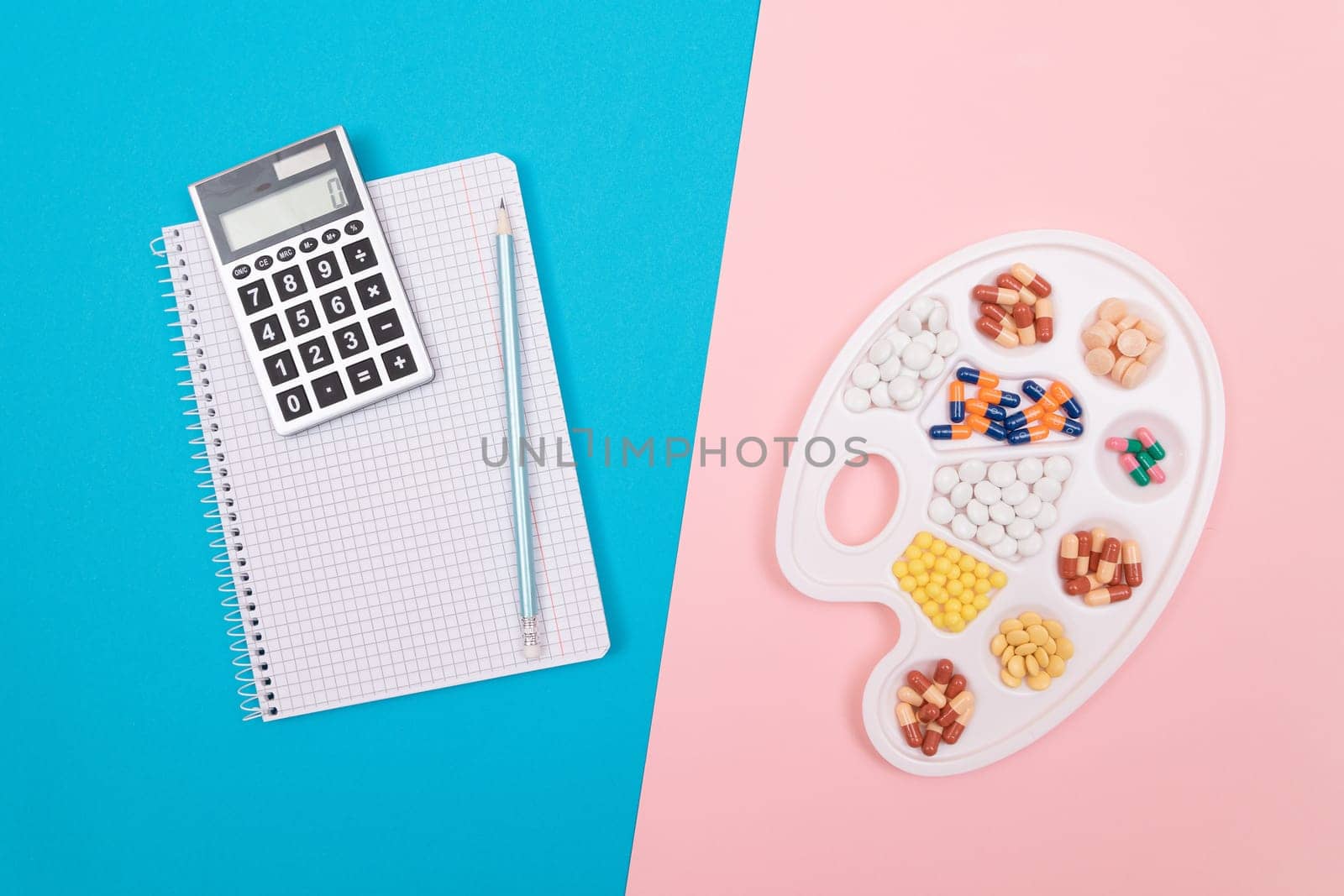 Global Pharmaceutical Industry and Treatment Costs - Different Colored Pills, Tablets and Capsules on White Art Palette with Calculator and Notepad Lying on Split Blue and Pink Background, Flat Lay