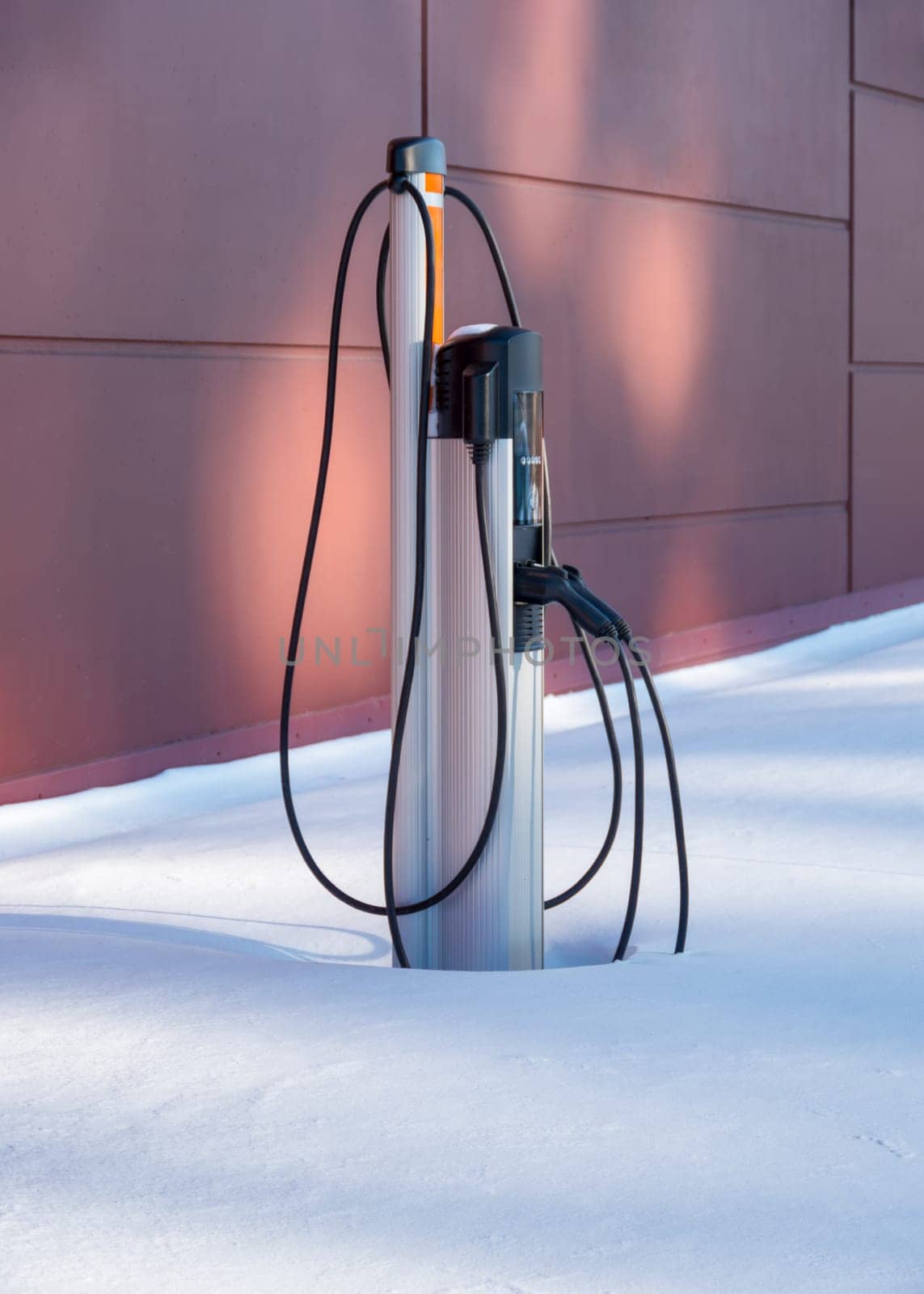 Electric vehicle charging station on winter season. Electric charging point in snow pile