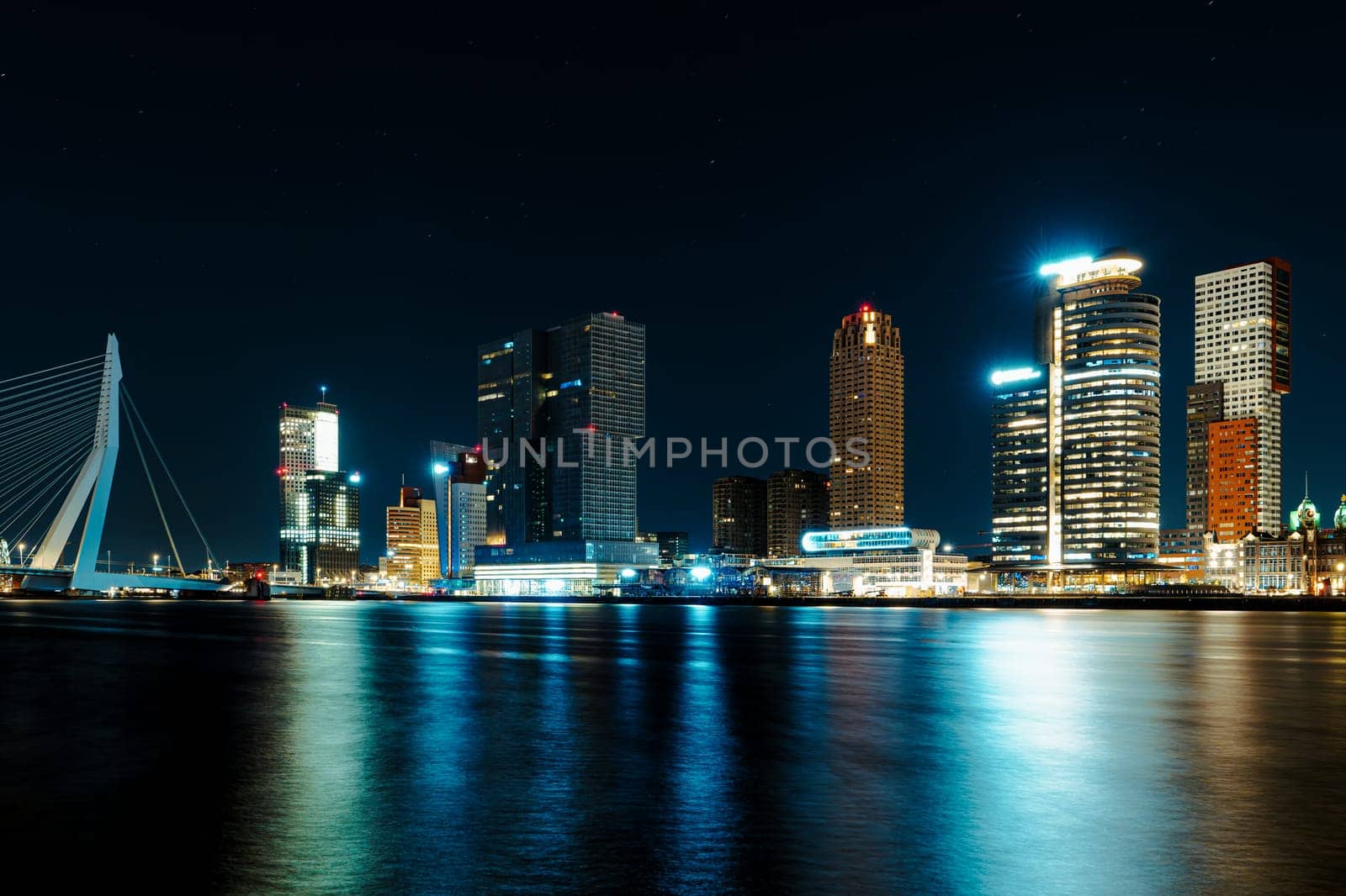 A mesmerizing night panorama of the city of Rotterdam, showcasing its modern high-rise architecture against a backdrop of a starry night sky, creating an enchanting and captivating urban landscape.