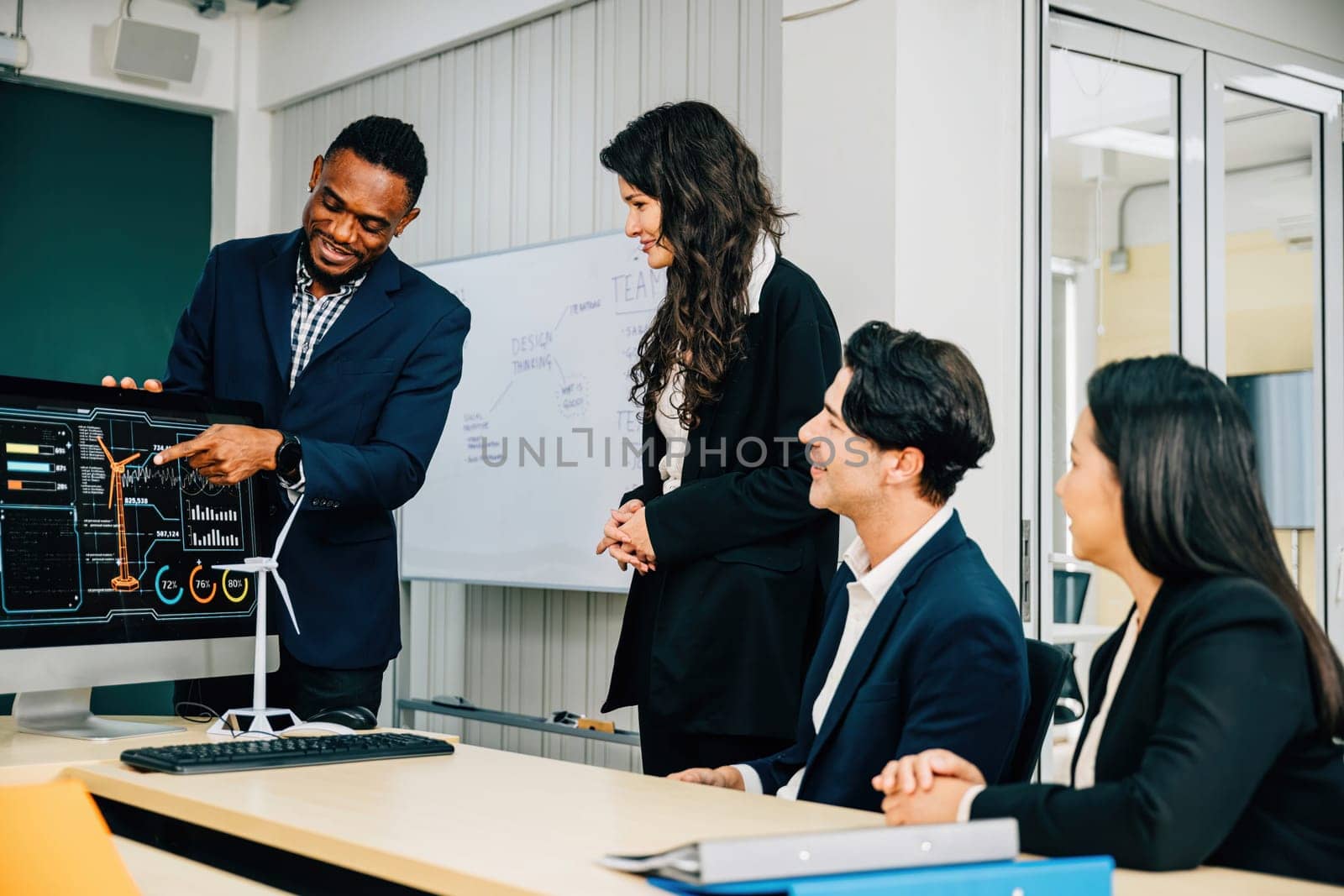 Colleagues collaborate in a modern office on a startup project, emphasizing teamwork. Three people analyze data on a computer, promoting brainstorming and cooperation.